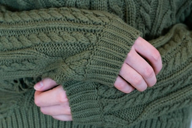 A close-up shot of a man's hand gently touching the soft texture of a navy blue cashmere sweater. The background is blurred to emphasize the sweater's luxurious feel.