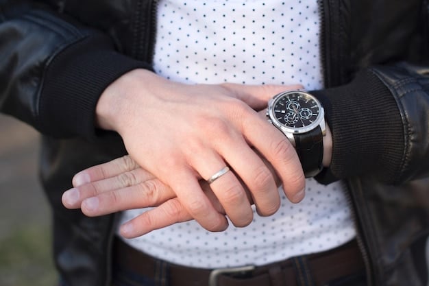 A close-up shot of a man's wrist showcasing a luxury watch paired with a sleek, thin metal bracelet. The focus is on the textures and craftsmanship of both items, highlighting their elegant and modern design.