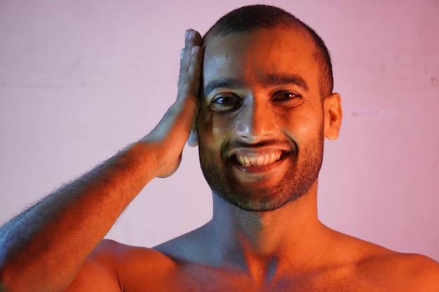 A man is smiling confidently at the camera, showcasing his clear and healthy skin. The lighting highlights his complexion and the effectiveness of his skincare routine.