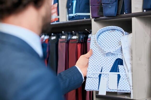 A close-up shot of a well-organized men's closet, showcasing various business casual essentials. Focus on different textures and colors: a neatly folded stack of button-down shirts (light blue, white, gray), a selection of blazers (navy, charcoal gray, brown tweed), chinos in different earth tones (khaki, olive, navy), and dress shoes/loafers arranged neatly below. A glimpse of a watch collection and some stylish belts are also visible.