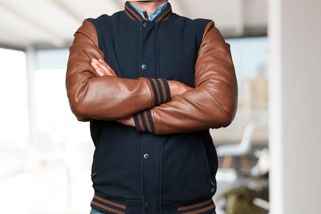 A close-up shot of a man wearing a leather bomber jacket with a simple white t-shirt and dark jeans. The focus should be on the texture and details of the jacket, showcasing its quality and style.