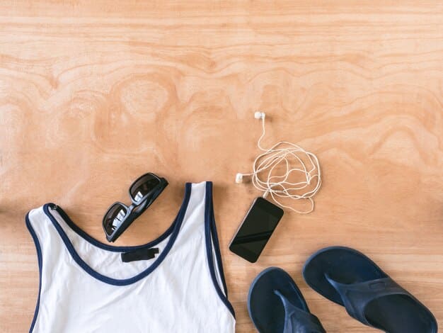 A close-up shot of various athleisure clothing items laid out on a wooden surface, including leggings, a sports bra, a zip-up hoodie, and a pair of running shoes. The lighting is soft and natural.