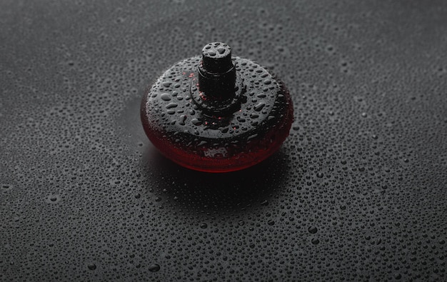 A close-up shot of a perfume bottle being sprayed, with droplets of the fragrance visible in the air against a blurred background, emphasizing the sensory experience of applying perfume.